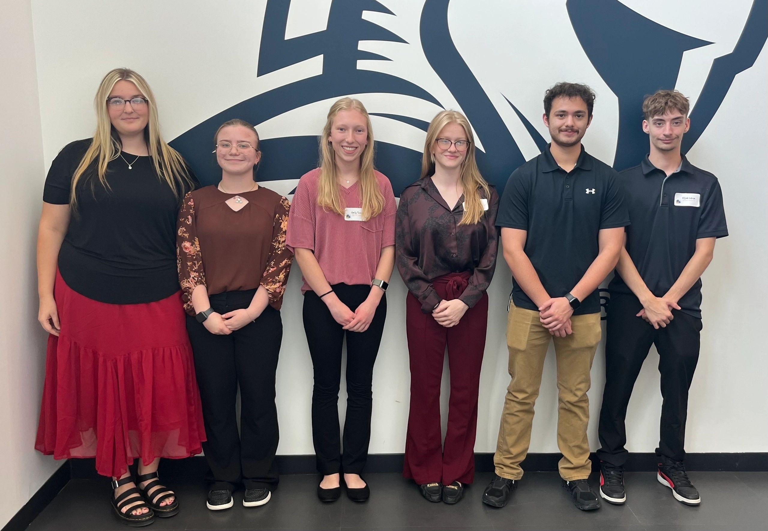 South Dakota FBLA: members posing in front of a wall mural