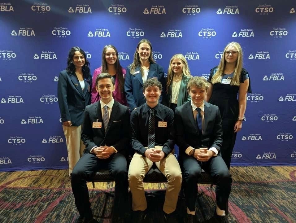 South Dakota FBLA: members posing in front of an FBLA backdrop
